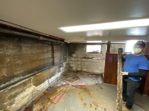 Basement foundation wall showing moisture damage, cracks, and structural concerns during renovation in a New Jersey home