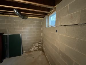 Horizontal foundation wall crack in unfinished basement showing possible structural movement and moisture issues